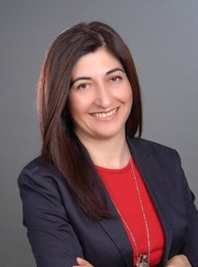 Kırmızı bluz ve lacivert ceketli gülümseyen kadının portresi