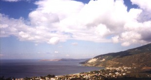 Ocaklar'da dağ eteğindeki kıyı yerleşimi, deniz ve bulutlu gökyüzü