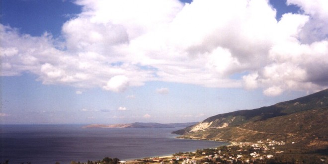 Ocaklar'da dağ eteğindeki kıyı yerleşimi, deniz ve bulutlu gökyüzü