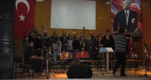 Türk bayrağı önünde sahnede hazırlanan koro ve müzik grubu