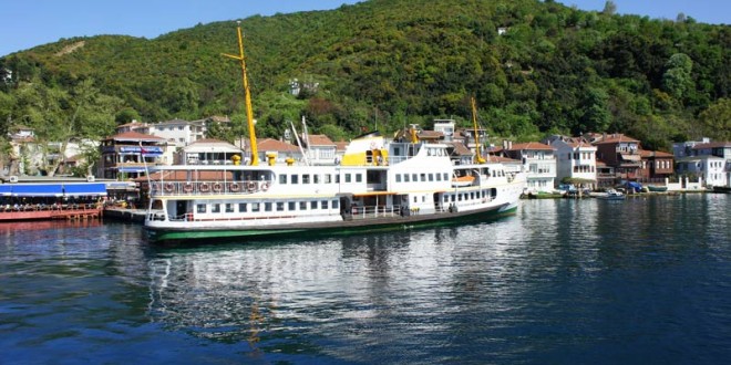 Boğaz'da yeşil tepenin önünde yolcu vapuru ve köy evleri