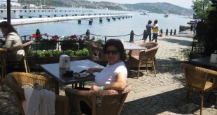 Boğaz kıyısında kafe terasında hasır sandalyede oturan kadın