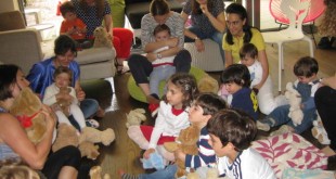 Evde oyuncak ayılarla yerde oturan çocuklar ve anneleri