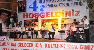 Ramazan etkinliği sahnesinde müzik topluluğu ve arkadaki pankart