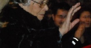 Şapkalı yaşlı kadın salonda elini kaldırmış yakın çekim