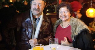 Gala gecesinde kafede masa başında poz veren bereli adam ve kürklü kadın