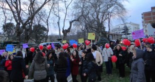 Parkta kırmızı balonlarla toplanan kalabalık kadın grubu