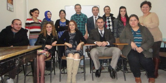 Sınıfta sıralara oturmuş diksiyon kursu katılımcıları toplu poz veriyor