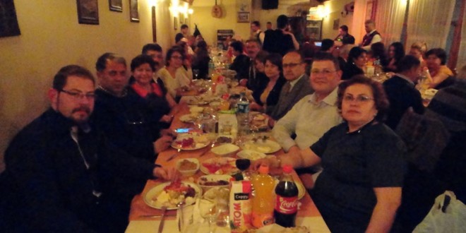 Ahşap tavanlı restoranda uzun masada yemek yiyen kalabalık grup