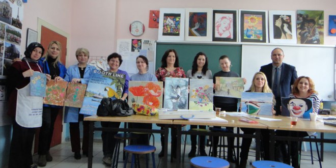 Sanat kursu katılımcılarının çalışmalarıyla birlikte sınıfta toplu pozu