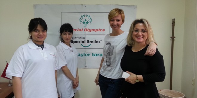 Special Olympics banner önünde poz veren grup