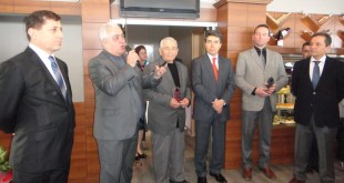 Turizm haftası etkinliğinde mikrofonla konuşan adam ve yanındaki konuklar
