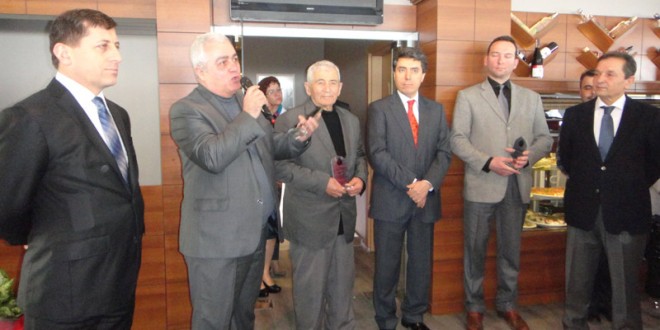 Turizm haftası etkinliğinde mikrofonla konuşan adam ve yanındaki konuklar