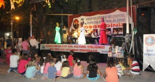 Ramazan etkinliği sahnesini izleyen yerde oturan çocuklar