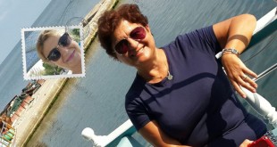 Teknenin güvertesinde deniz kenarında selfie çeken gülümseyen kadın
