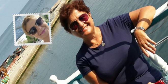 Teknenin güvertesinde deniz kenarında selfie çeken gülümseyen kadın