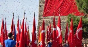 Bayram töreninde konfeti altında kırmızı bayraklar ve büyük bayrak