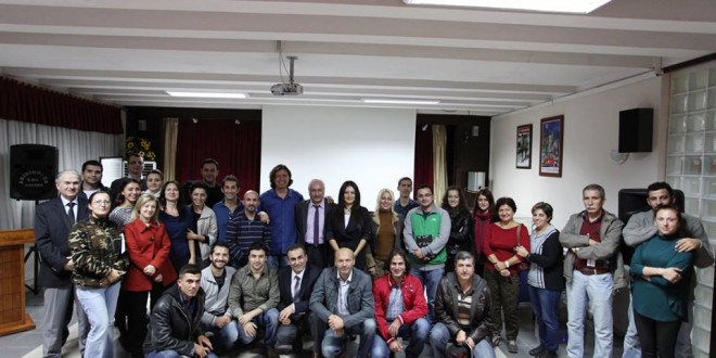Toplantı salonunda ayakta ve oturarak toplu hatıra çekilen kalabalık grup