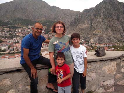 Dağlık bir manzara önünde poz veren bir aile