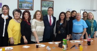 Uzun masanın arkasında ayakta poz veren proje katılımcıları
