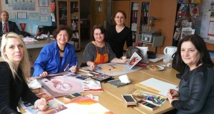 Sanat atölyesinde masada resim çizen oturan bir grup kadın