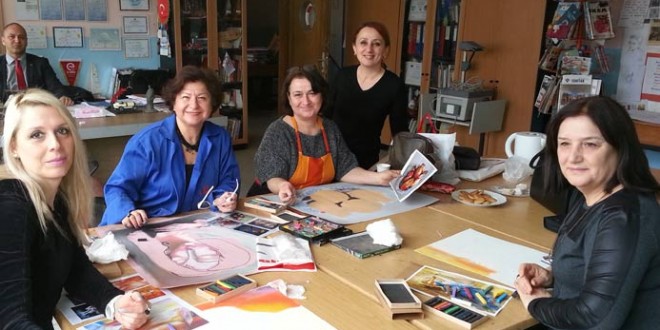 Sanat atölyesinde masada resim çizen oturan bir grup kadın