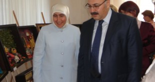 Sergi salonunda yürüyen başörtülü kadın ve yanındaki erkek