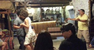 Eski taş mekânda dans eden kadın ve erkek ile izleyenler