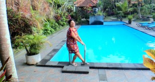 Ubud Bali'de otel havuzunun kenarında duran kadın görülüyor