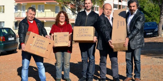 Elinde kutu taşıyan beş erkek dışarıda duruyor