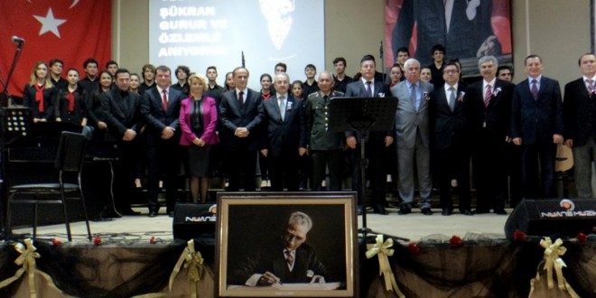 Sahnede Atatürk portresi önünde duran koro görülüyor