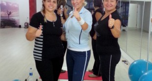 Spor salonunda poz veren üç kadın görülüyor