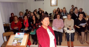 Toplantı salonunda ayakta konuşma yapan bir kadın