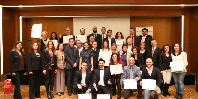 Sertifika töreninde bir arada poz veren kalabalık grup