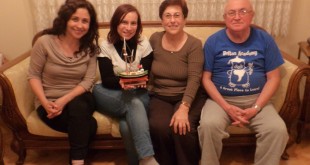 Ev sohbetinde kanepede oturan dört kişi pasta ile poz veriyor