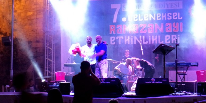 Ramazan etkinliğinde sahnede birbirine çiçek veren iki erkek sanatçı