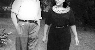 Parkta yürüyen bir çiftin siyah beyaz eski fotoğrafı.