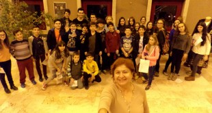 Lobide bir grup çocukla poz veren bir kadın.
