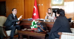 Makam odasında bayrak önünde toplantı yapan grup.