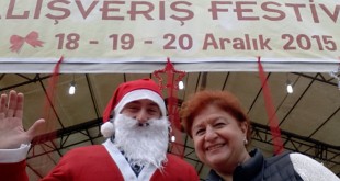 Alışveriş festivalinde Noel Baba ile poz veren bir kadın.