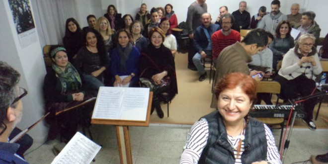 Konser salonunda nota sehpası önünde oturan dinleyiciler