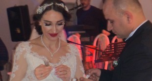 Gelin ve damat masada oturarak poz veriyor