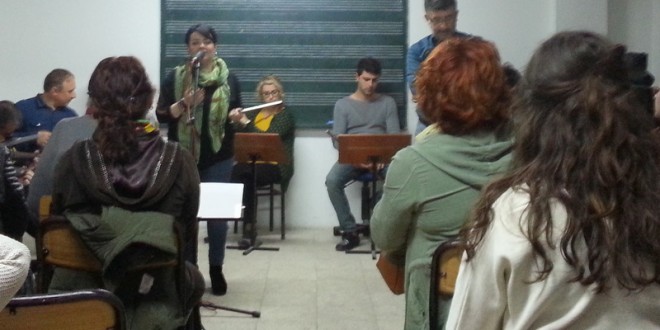 Küçük bir grubun izlediği piyano ve gitar dinletisi