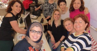 Sınıfta dört kadın selfi çubuğuyla birlikte poz veriyor