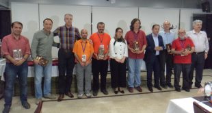 İç mekanda kalabalık bir grup ödül töreninde toplu poz veriyor