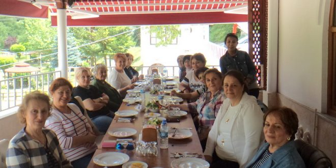 Uzun masa boyunca oturan kalabalık kadınlar birlikte yemek yiyor