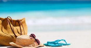 Plaj kumunda şapka, çanta ve terlikten oluşan tatil düzeni