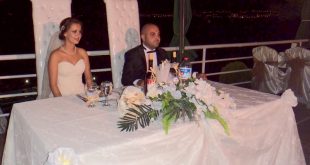 Düğün töreninde süslü masada oturan gelin ve damat