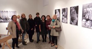 Sergi duvarındaki fotoğraflar önünde duran grup