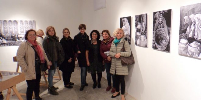 Sergi duvarındaki fotoğraflar önünde duran grup